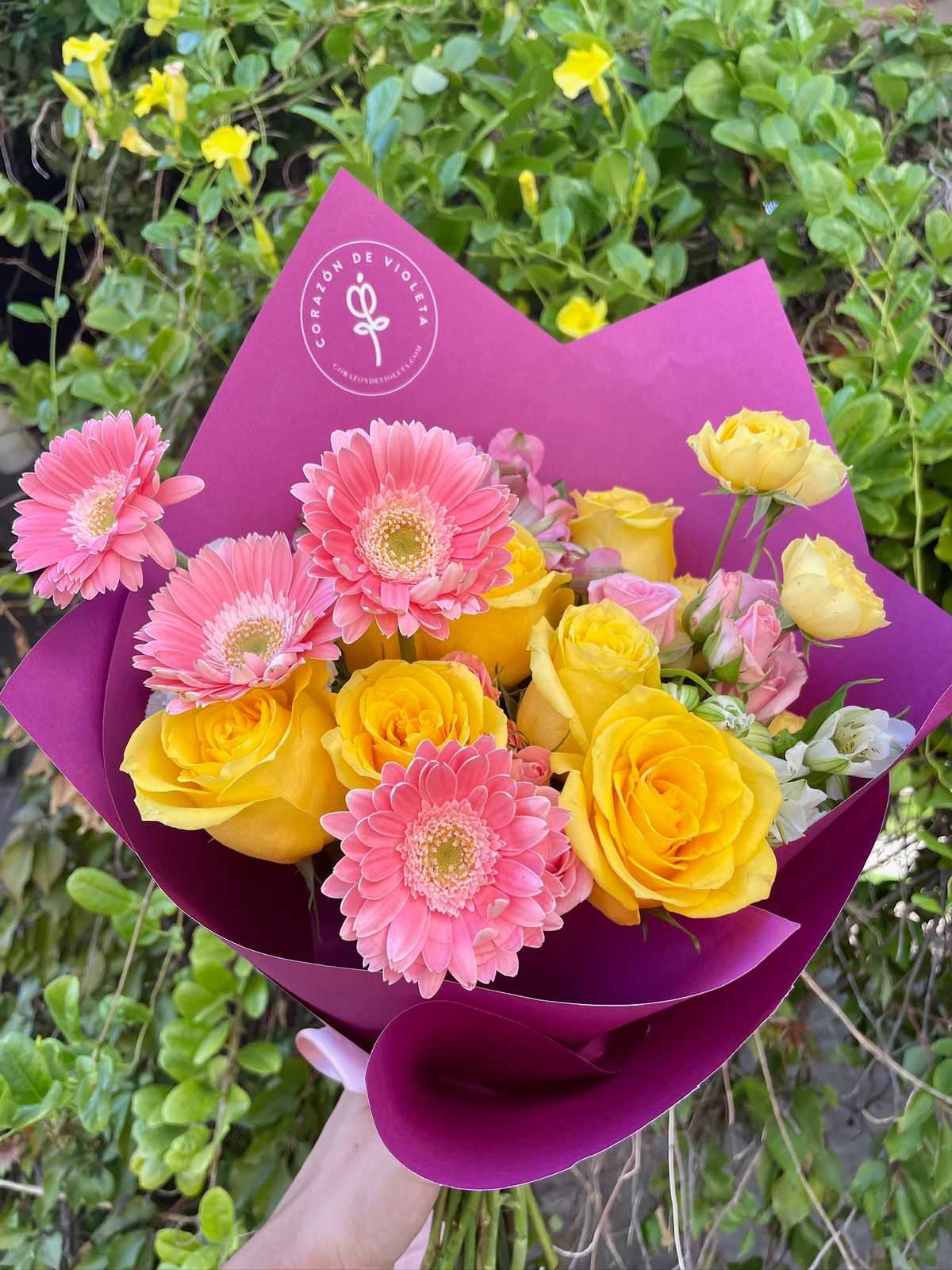 Bouquet de rosas amarillas y gerberas rosas con envoltura morada